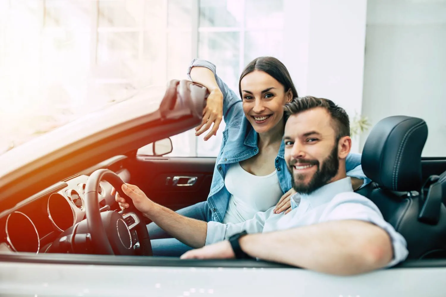 Friends waving from a yellow convertible on an open road
